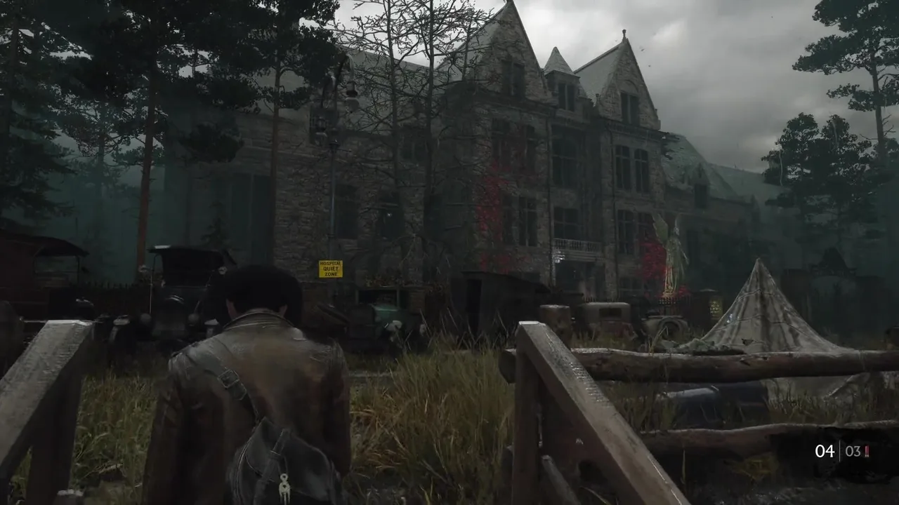 A gothic stone hospital with a Quiet Zone sign on overgrown grounds
